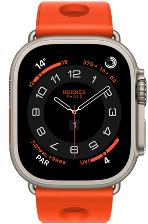 Apple Watch Hermès Ultra 3, Circular analog watch face, (hour, minute and second hands, complications: Weather, activity rings, Paris time and UV Index), titanium case, natural colour, right side exterior, Digital Crown, raised side button, paired with Scub'H Diving band, orange néon colour (bright orange), moulded rubber material, circular cut-outs centred