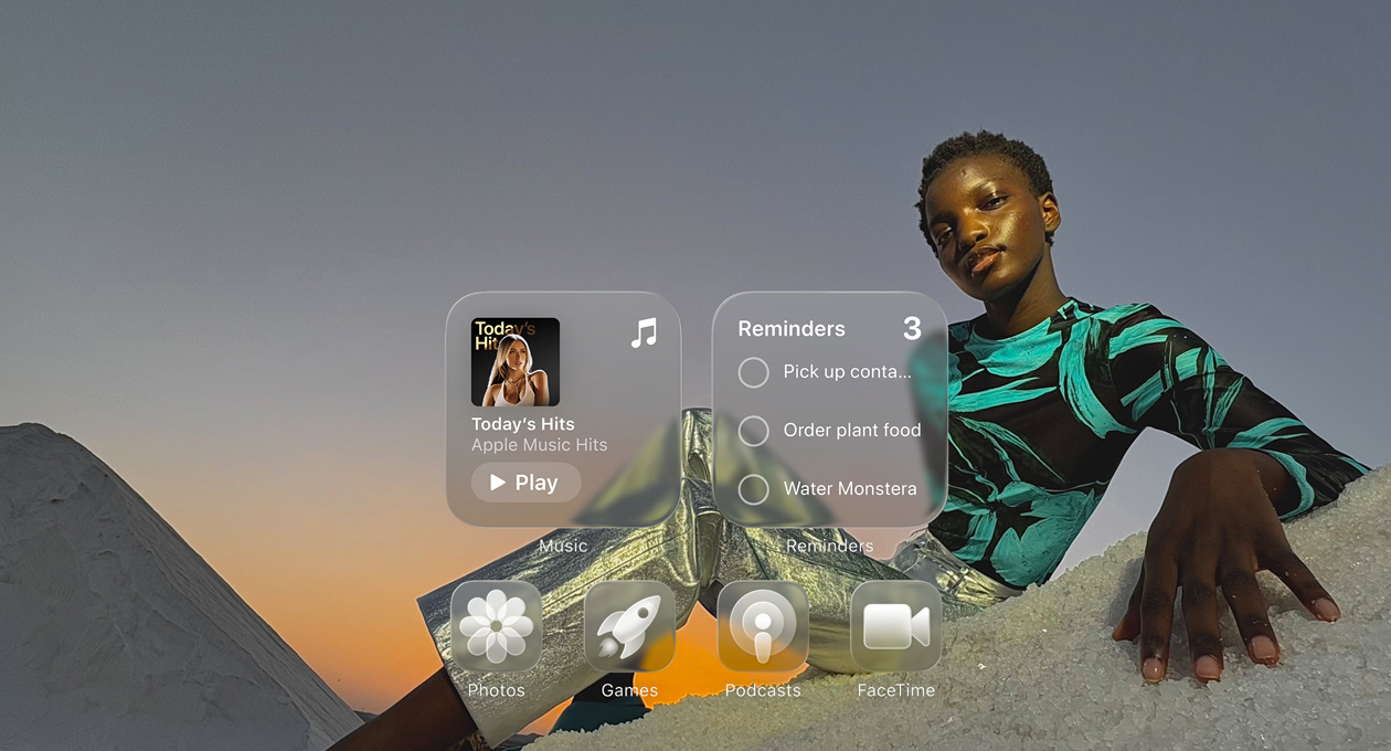 Liquid Glass display with clear app icons, like Apple Music, Reminders, Photos, Games, Podcasts and FaceTime refracting against the wallpaper