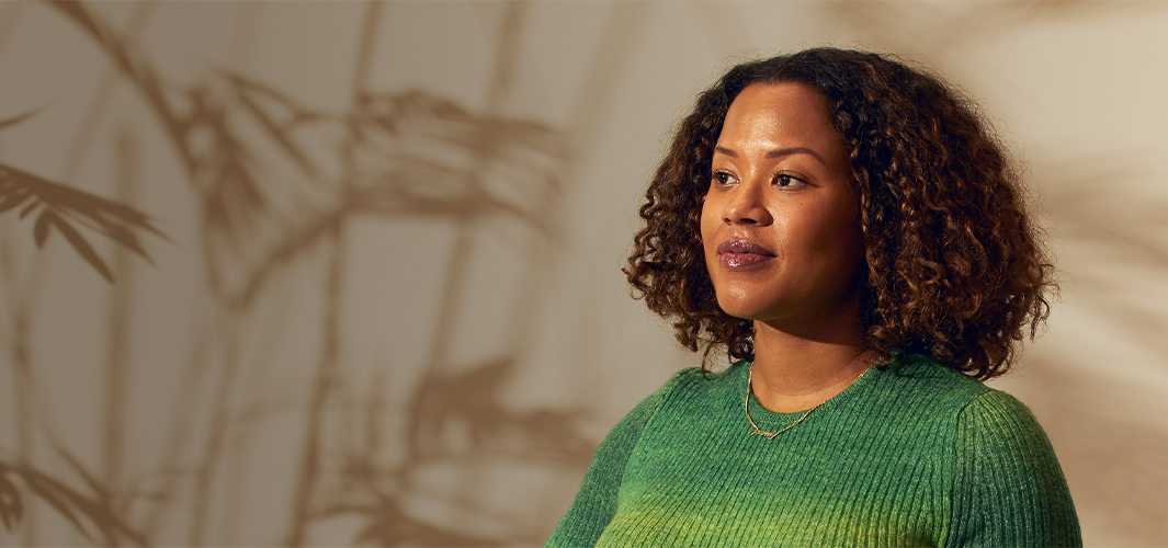 Sydney de pie en el interior y mirando hacia su derecha con una gesto que transmite seguridad.