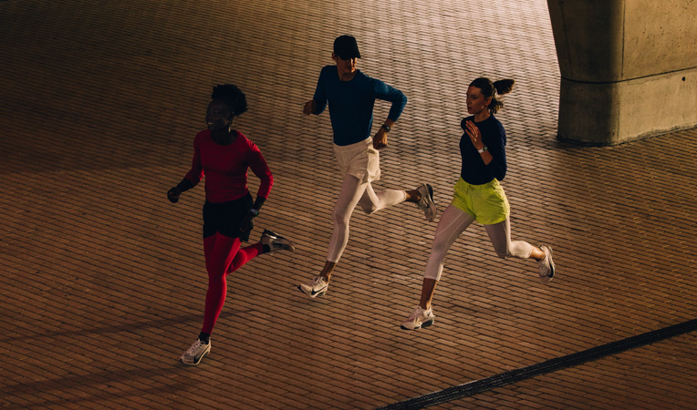 Three people running together, all wearing Apple Watch