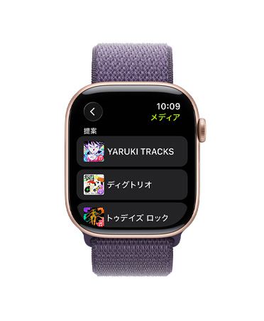 ローズゴールドアルミニウムケースのApple Watch Series 11。Apple Music、音楽とポッドキャストのおすすめが表示されている。右側の外観にはDigital Crownがあり、パープルフォグのスポーツループバンドが取りつけられている