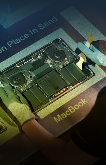 Handen met handschoenen aan die een MacBook demonteren, interne componenten zijn zichtbaar