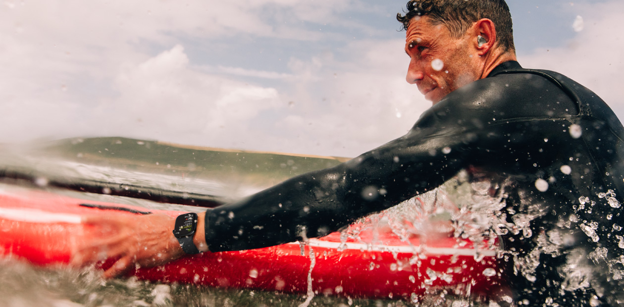 En mand surfer med et Apple Watch på armen.