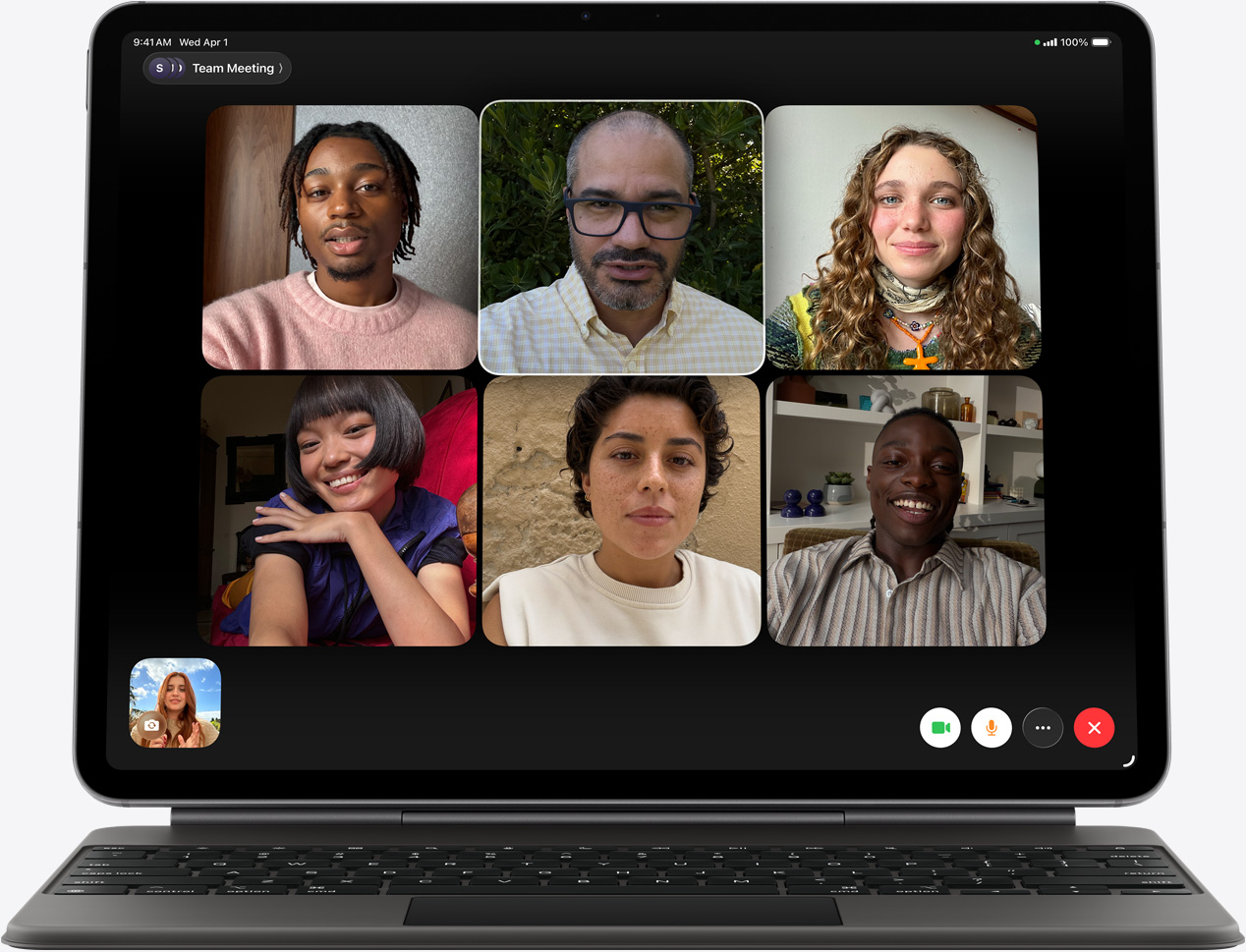 iPad Air, vist forfra, Magic Keyboard, sort farve, FaceTime-opkald på skærmen, flere af deltagerne er synlige