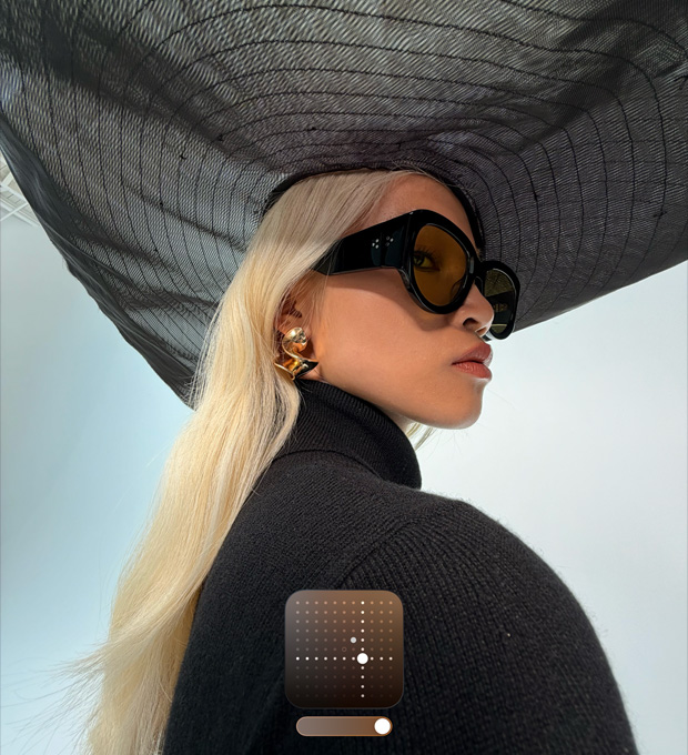 Portrait d’une femme coiffée d’une capeline noire présentant le Style photographique Éclatant, qui ravive les clichés pris par faible luminosité ou avec le mode Nuit