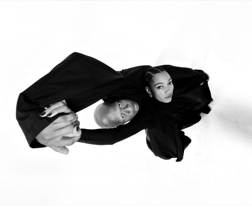 A wide-angle black-and-white photograph of two people demonstrates the capabilities of the Ultra Wide camera on iPhone 17 Pro