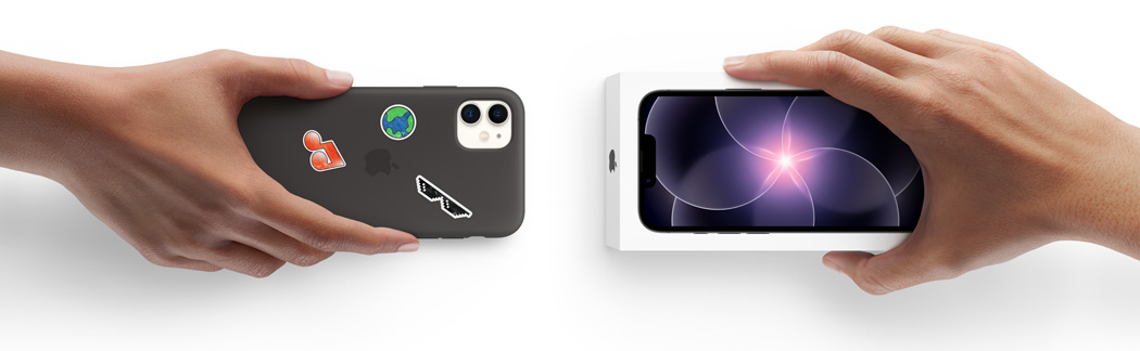 Two hands side by side, hand holding iPhone 11 in Silicone Case with stickers on back exterior, trade-in, with hand holding new iPhone 17e box