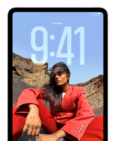iPad showing Lock Screen where large numerals for the time appears behind the picture of a person sitting