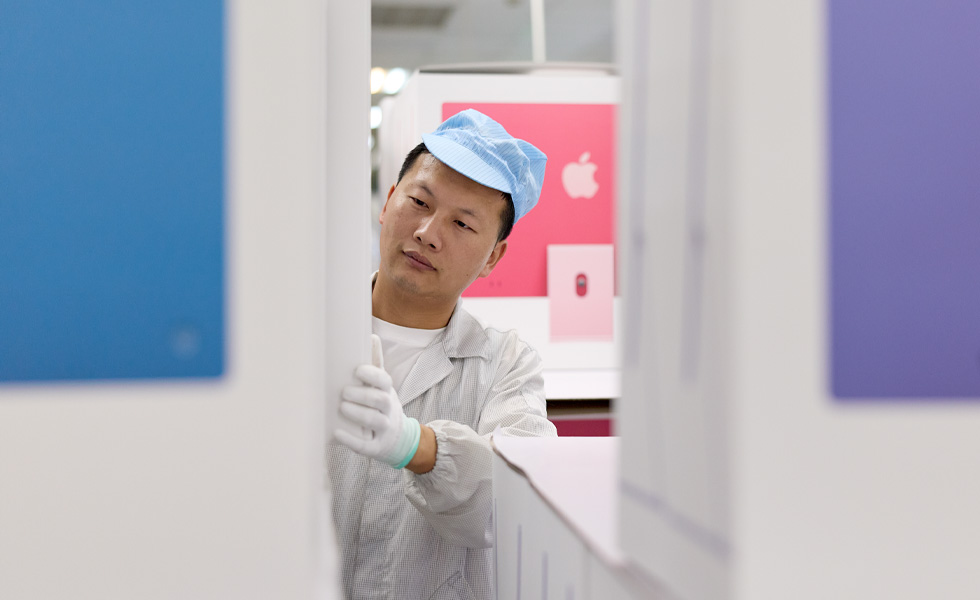 Fabrieksmedewerker in beschermende kleding inspecteert apparatuur in een productiefaciliteit.