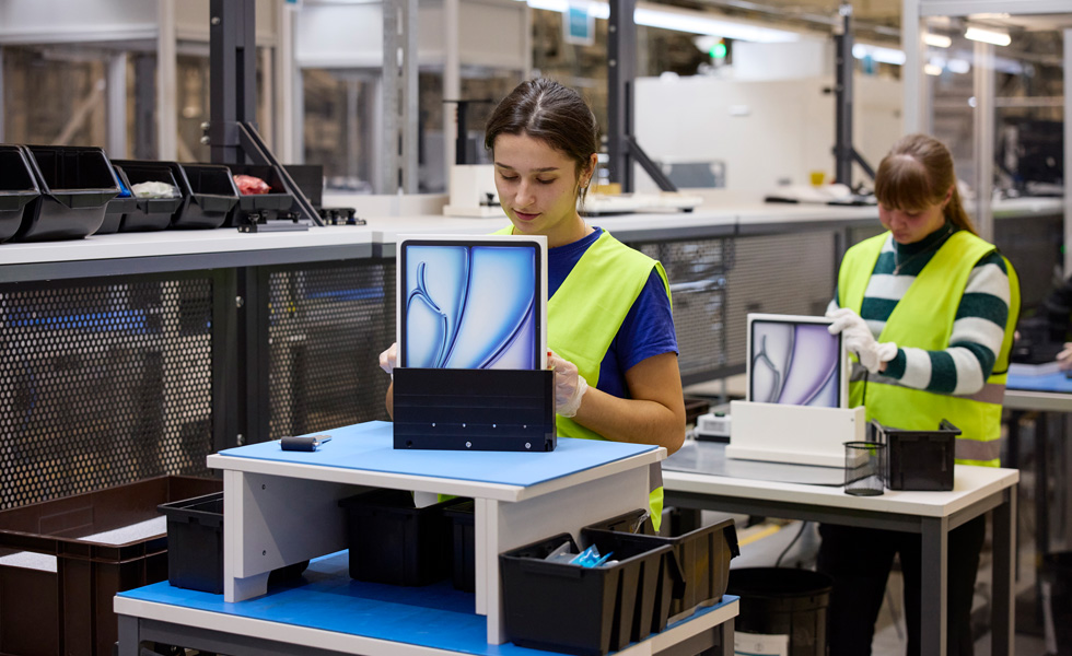 Twee medewerkers met veiligheidsvesten zitten op hun werkplek met productverpakkingen