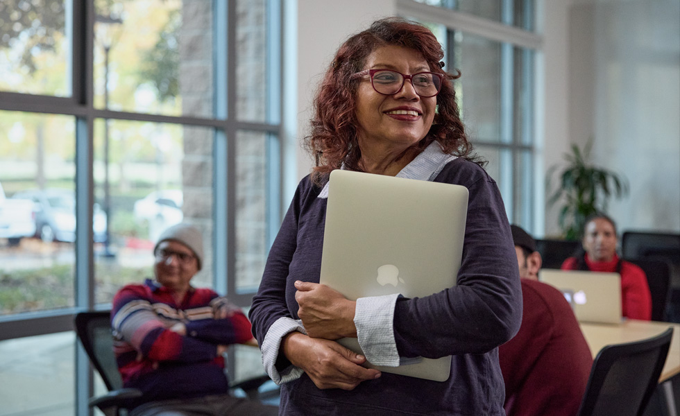 Iemand neemt een laptop mee naar een klaslokaal of andere leeromgeving