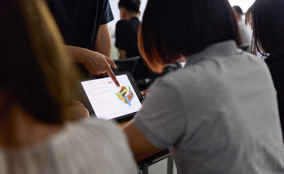 Iemand deelt feedback over een voorwerp op een tabletscherm in een klaslokaal